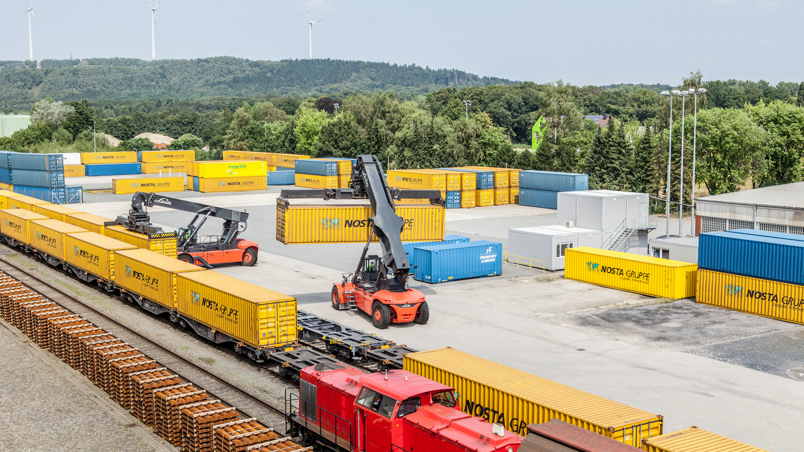 Container werden mit zwei Reachstacker auf einen Zug aufgeladen